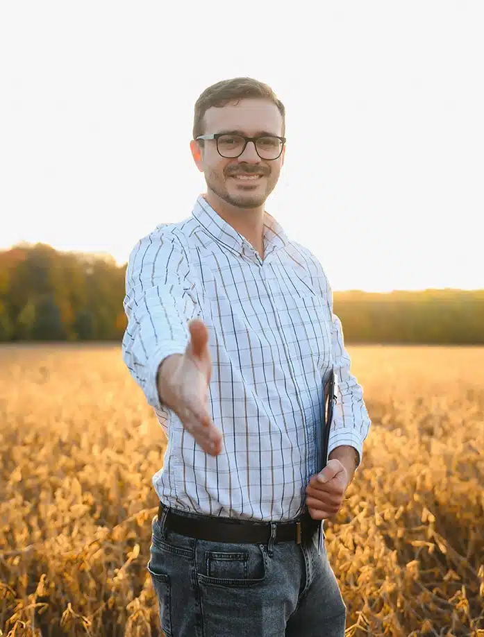 agronomist shaking hands standing in a soybean field
